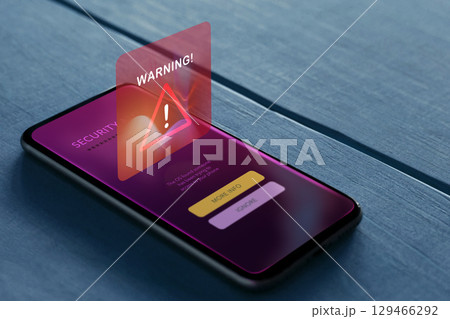 Smartphone on table displays a cybersecurity alert, Warning risks of cybercrime, data breach, and digital vulnerability 129466292