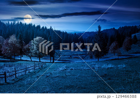 countryside mountain landscape in autumn at night. rural road winding through valley among field and trees on the hill. scenic vista in fall season for travel and outdoor adventure in full moon light 129466388