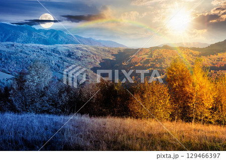 autumn mountain landscape. day and night time change concept. beautiful countryside in highlands with rural fields and colorful deciduous trees. rolling hills with sun and moon at twilight autumn mountain landscape. day and night time change concept. beautiful countryside in highlands with rural fields and colorful deciduous trees. rolling hills with sun and moon at twilight 129466397