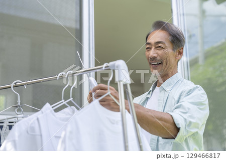 洗濯物を干すシニア男性 129466817