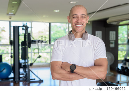 Confident bald Hispanic man posing in gym, fitness and strength-focused lifestyle portrait 129466961