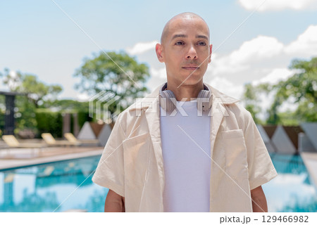 Latin bald man poolside in summer outfit, wellness lifestyle, vacation and outdoor portrait concept Latin bald man poolside in summer outfit, wellness lifestyle, vacation and outdoor portrait concept 129466982