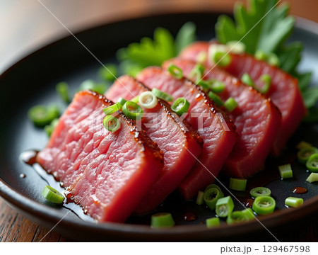 Close-up Culinary Seared Tuna Slices Topped with Scallions on Plate Food 129467598