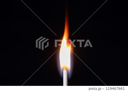 The flame, predominantly orange and yellow with a bright white core near the match head, extends upwards The flame, predominantly orange and yellow with a bright white core near the match head, extends upwards 129467661