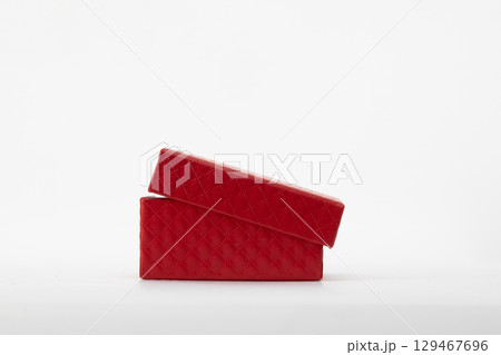 A slightly open red gift box with a textured lid, placed on a white background A slightly open red gift box with a textured lid, placed on a white background 129467696