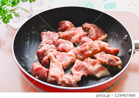 粉をまぶした豚肉を焼いていく 129467966