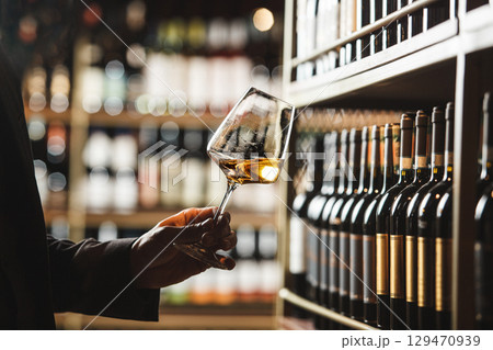 Wine Expert Evaluating Color of White Wine in Cellar 129470939