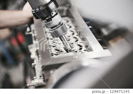Engine Valve Seat Repair in car workshop close up. Engine Valve Seat Repair in car workshop close up. 129471145