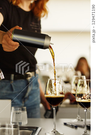 Faceless Woman Pouring Stout Beer from Can to The Glass for Participants Lecture During Tasting of Alcoholic Beverages.  129471190