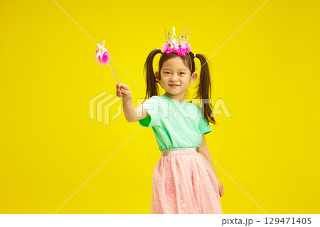 Playful Child Princess Waves Magic Wand Symbolises Kindness, Mercy and the Ability to Overcome Obstacles with the Help of Wonderful and Faith Standing Over Sunny Yellow Isolated Background Playful Child Princess Waves Magic Wand Symbolises Kindness, Mercy and the Ability to Overcome Obstacles with the Help of Wonderful and Faith Standing Over Sunny Yellow Isolated Background 129471405