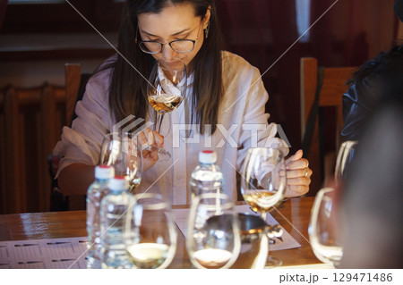 Woman Sitting at Table With Wine Glasses and Semmling it  129471486
