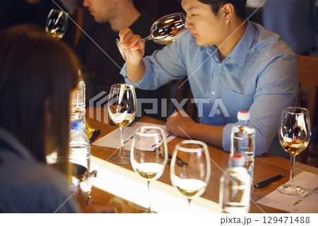Asian Sommelier Tasting Wine at Table 129471488