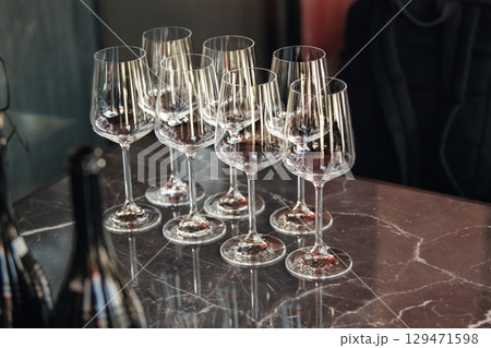 Few empty wine glasses on table near sparkling wine bottles. Wine tasting concept.  Few empty wine glasses on table near sparkling wine bottles. Wine tasting concept.  129471598