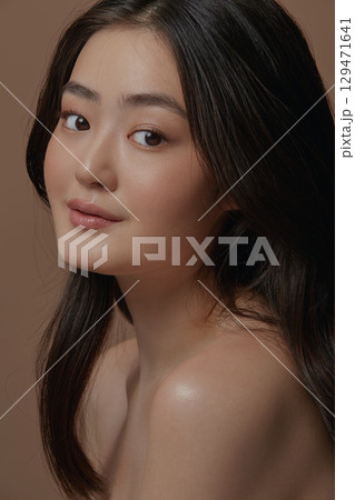 charming asian ethnicity woman with a healthy clean skin over beige isolated. Skin care, cosmetology and plastic surgery concept charming asian ethnicity woman with a healthy clean skin over beige isolated. Skin care, cosmetology and plastic surgery concept 129471641