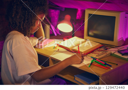 Girl writing notes at desk with open book in retro attic workspace Girl writing notes at desk with open book in retro attic workspace 129472440