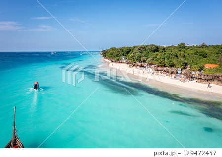 Tourists enjoy Nungwi Beach, Zanzibar, with its turquoise water and white sand Tourists enjoy Nungwi Beach, Zanzibar, with its turquoise water and white sand 129472457