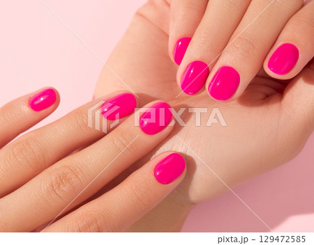 Close up beautiful womans hands with pink nail design. Manicure, pedicure beauty salon concept 129472585