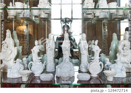 The Blanc de Chine porcelain figurines, beautifully crafted in white, depict figures like the Goddess of Mercy, Guanyin, symbolizing Chinese spirituality and cultural heritage. 129472714