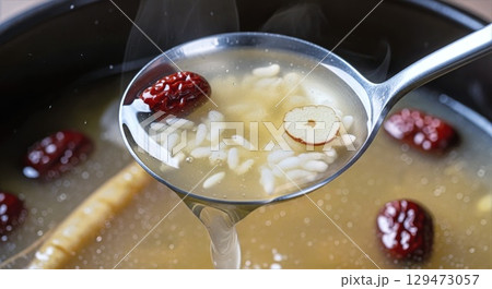 Korean samgyetang broth with glutinous rice and red dates in ladle	 129473057