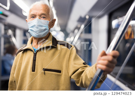 Portrait of mature man in personal protective equipment in subway carriage Portrait of mature man in personal protective equipment in subway carriage 129474023