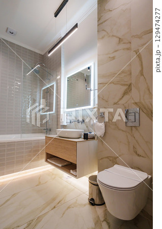 The interior of a modern bathroom is in beige tones.  129474277