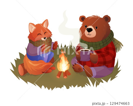 Cozy autumn campfire with friendly fox and bear in scarves sitting on grass warming hands and sipping hot cocoa cute woodland animals outdoor camping scene with steaming mug glowing fire cheerful 129474663