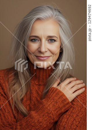 Portrait of a beautiful mature woman with long gray hair, smiling. 129474692
