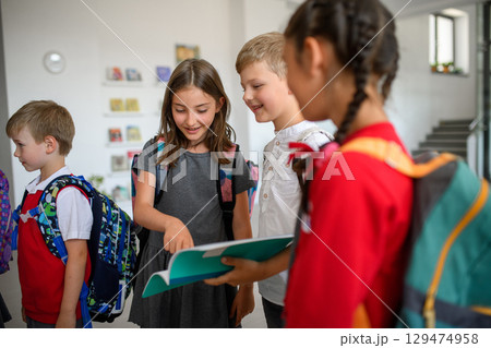 Happy schoolkids talking in school hallway. Happy schoolkids talking in school hallway. 129474958