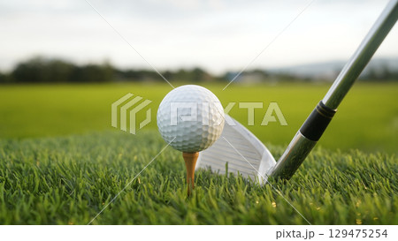Golf clubs and balls on a green lawn in a beautiful golf course with morning sunshine. 129475254