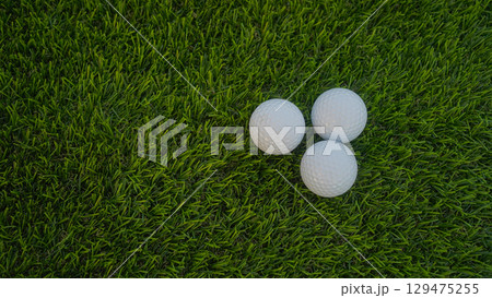 Golf balls on a green lawn in a beautiful golf course with morning sunshine. 129475255