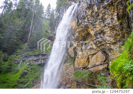 Johannes Waterfall cascades dramatically down rocky cliffs in Obertauern, Austria. Surrounded by lush greenery, this natural wonder draws visitors for breathtaking views and serene hiking experiences. Johannes Waterfall cascades dramatically down rocky cliffs in Obertauern, Austria. Surrounded by lush greenery, this natural wonder draws visitors for breathtaking views and serene hiking experiences. 129475297