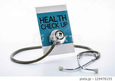Stethoscope rests against sign that reads Health Check Up, symbolizing medical examination and healthcare. image conveys sense of professionalism and care Stethoscope rests against sign that reads Health Check Up, symbolizing medical examination and healthcare. image conveys sense of professionalism and care 129476155