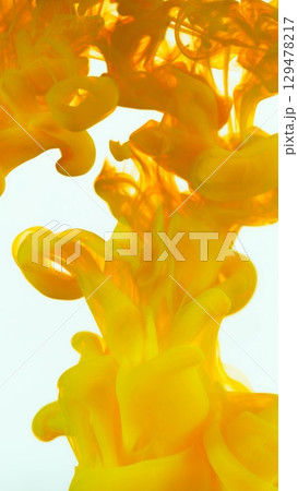 Yellow Ink Abstract Shape Under the Water. Isolated on White Background. Vertical Aspect Ratio. 129478217