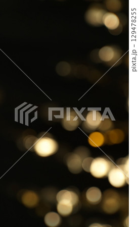 Abstract Golden Bokeh Glitter Background. Defocused Blur Spot Lights Isolated on Black Background. 129478255
