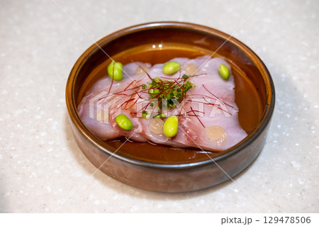 Dry aged fish with Japanese Yuzu Ponzu sauce served on plate 129478506