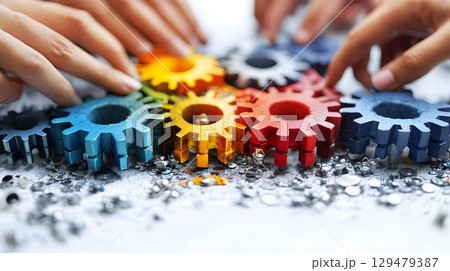 Hands assembling vibrant gears, showcasing teamwork and collaboration concept Hands assembling vibrant gears, showcasing teamwork and collaboration concept 129479387