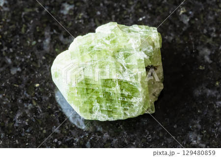 sample of raw diopside crystal on black granite sample of raw diopside crystal on black granite 129480859