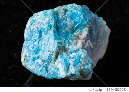 sample of raw apatite mineral on black granite 129480908