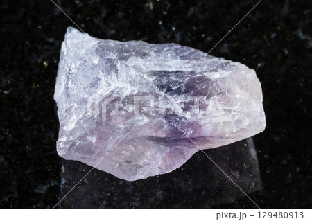unworked purple striped fluorite mineral on black 129480913