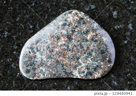 polished basalt with hematite mineral on black 129480941