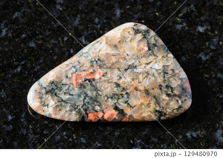 tumbled gneissoid granite mineral on black 129480970