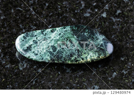 tumbled peridotitic komatiite rock on black 129480974