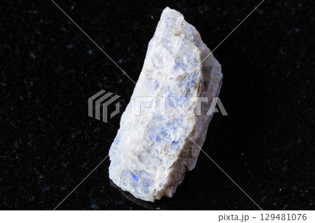 sample of raw belomorite mineral on black granite 129481076