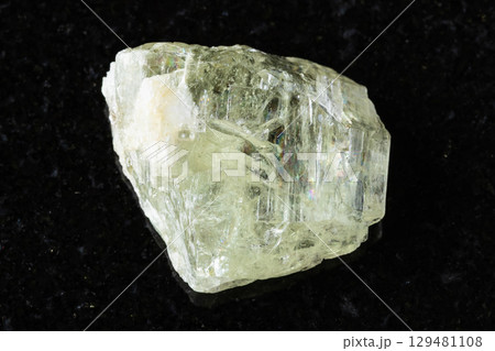 sample of raw hiddenite mineral on black granite sample of raw hiddenite mineral on black granite 129481108