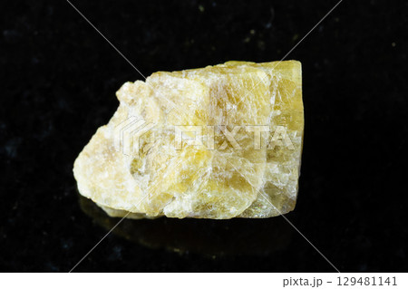 sample of raw yellow tourmaline mineral on black 129481141