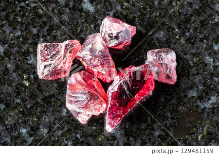sample of several raw pyrope crystals on black sample of several raw pyrope crystals on black 129481159
