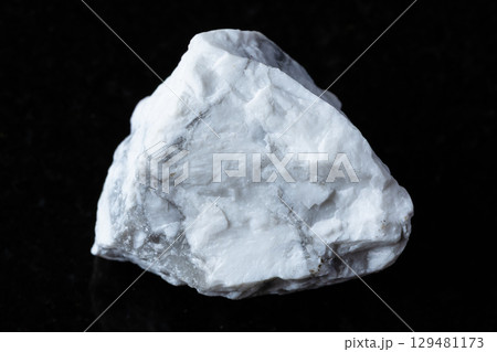 sample of raw howlite rock on black granite sample of raw howlite rock on black granite 129481173