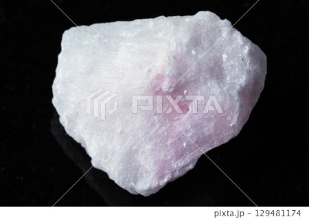 sample of raw pink aragonite mineral on black 129481174