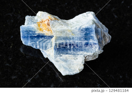 sample of unworked kyanite rock on black granite 129481184