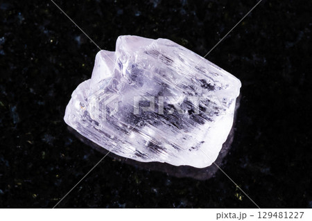sample of raw kunzite mineral on black granite 129481227
